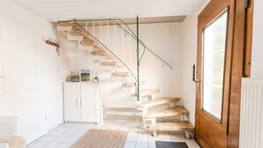 Eine Treppe mit Holzvertäfelung, weißen Wänden und einer Tür mit Fenster.