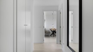 A modern, minimalist hallway with a dining area in the distance. - Santangelo | Sea views - terrace - pool (Benalmádena)