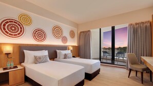A hotel room with two beds, a desk, and a view of the outdoors. - Lemon Tree Resort, Somnath (Veraval)