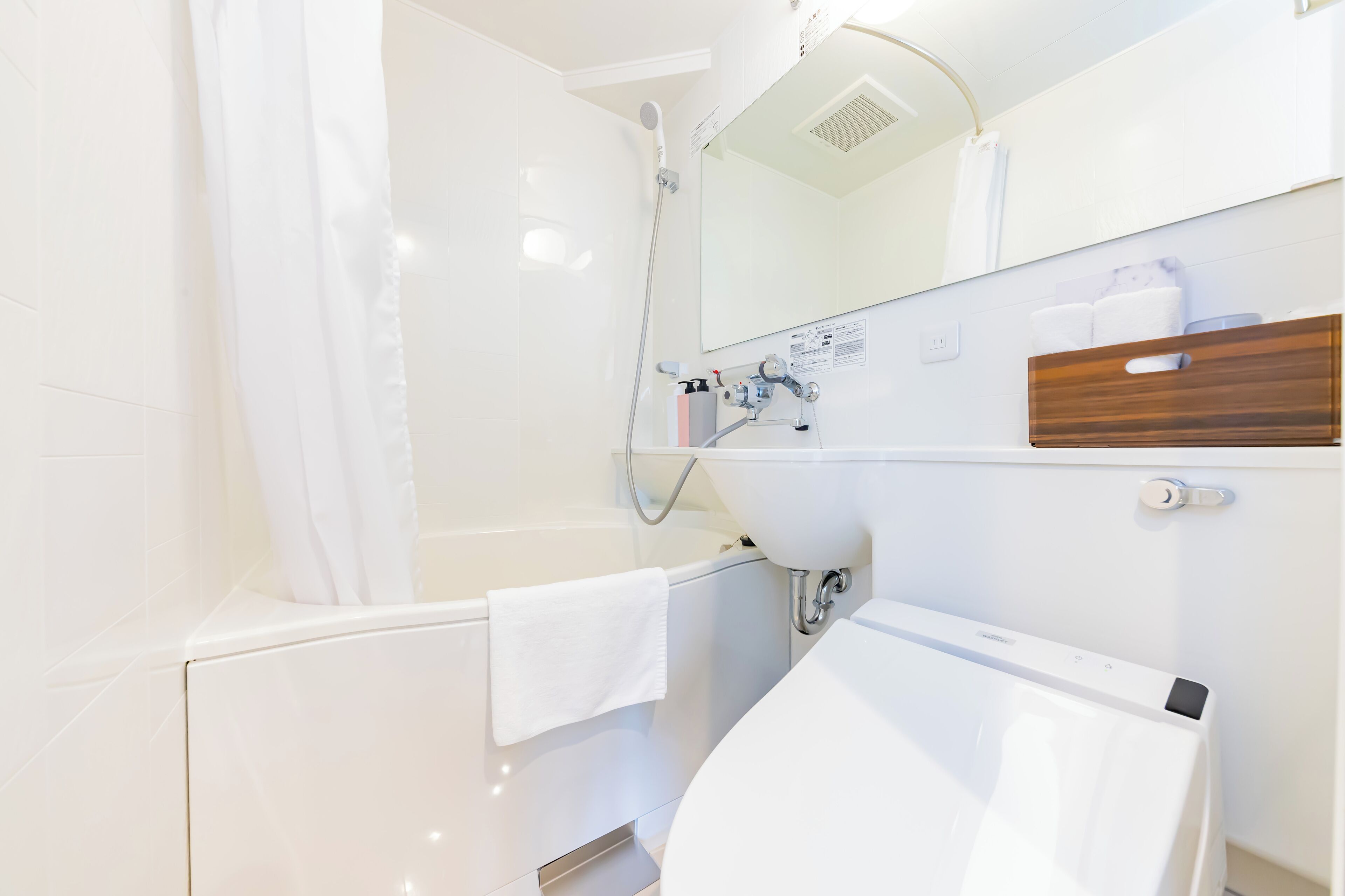 A modern bathroom with a bathtub, a sink, and a mirror.