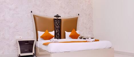 A neatly made bed with a headboard, a bedside table with drawers, and a wall with a textured pattern.
