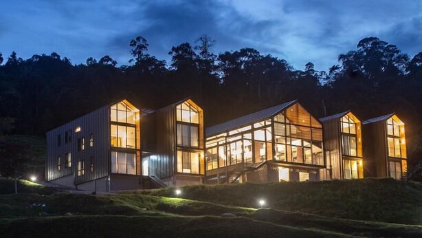 A modern, multi-story building with large windows and a flat roof, surrounded by a natural landscape. - Talula Hill Farm Resort  (Kluang)