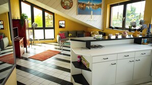 Eine geräumige Küche mit einer großen Kochinsel, ein Essbereich mit einer Sitzecke und ein Wohnzimmer mit einer Couch.
