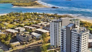 Zona residencial costera con edificios altos, una playa y una vista despejada del océano.