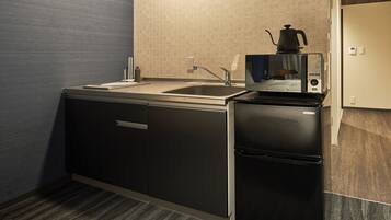 Una cocina compacta con un fregadero, estufa y refrigerador.