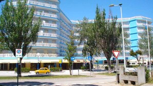 Un hôtel à plusieurs étages doté de balcons, d’un panneau indiquant qu’il est interdit de se garer et d’un panneau de signalisation.
