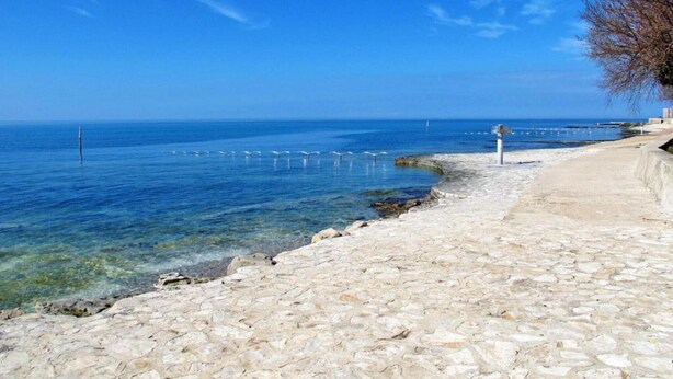 A coastal stone pathway leading to the sea, clear blue water, and a distant buoy. - Villa in Istria with Heated Eco Pool (Brtonigla)