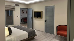 Une chambre d’hôtel avec un lit, une télévision et une porte.
