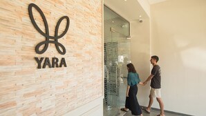 Une entrée moderne d’un bâtiment, avec une enseigne « YARA » sur un mur à texture.