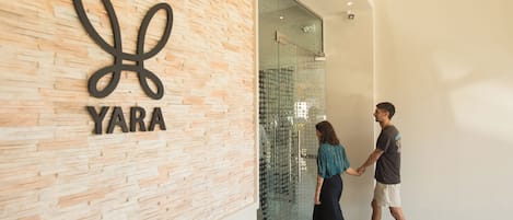 A modern building entrance with a 'YARA' sign on a textured wall.