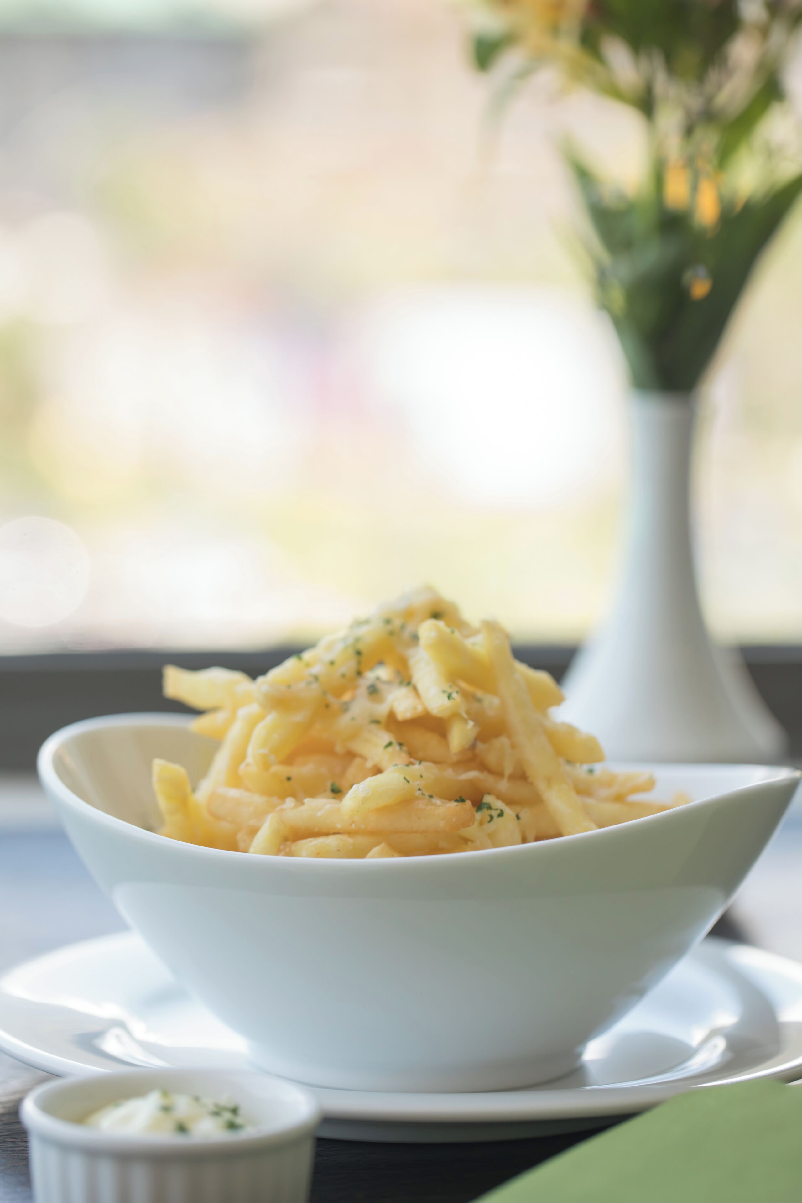 Un bol de pâtes avec une petite portion de sauce, posé sur une table.