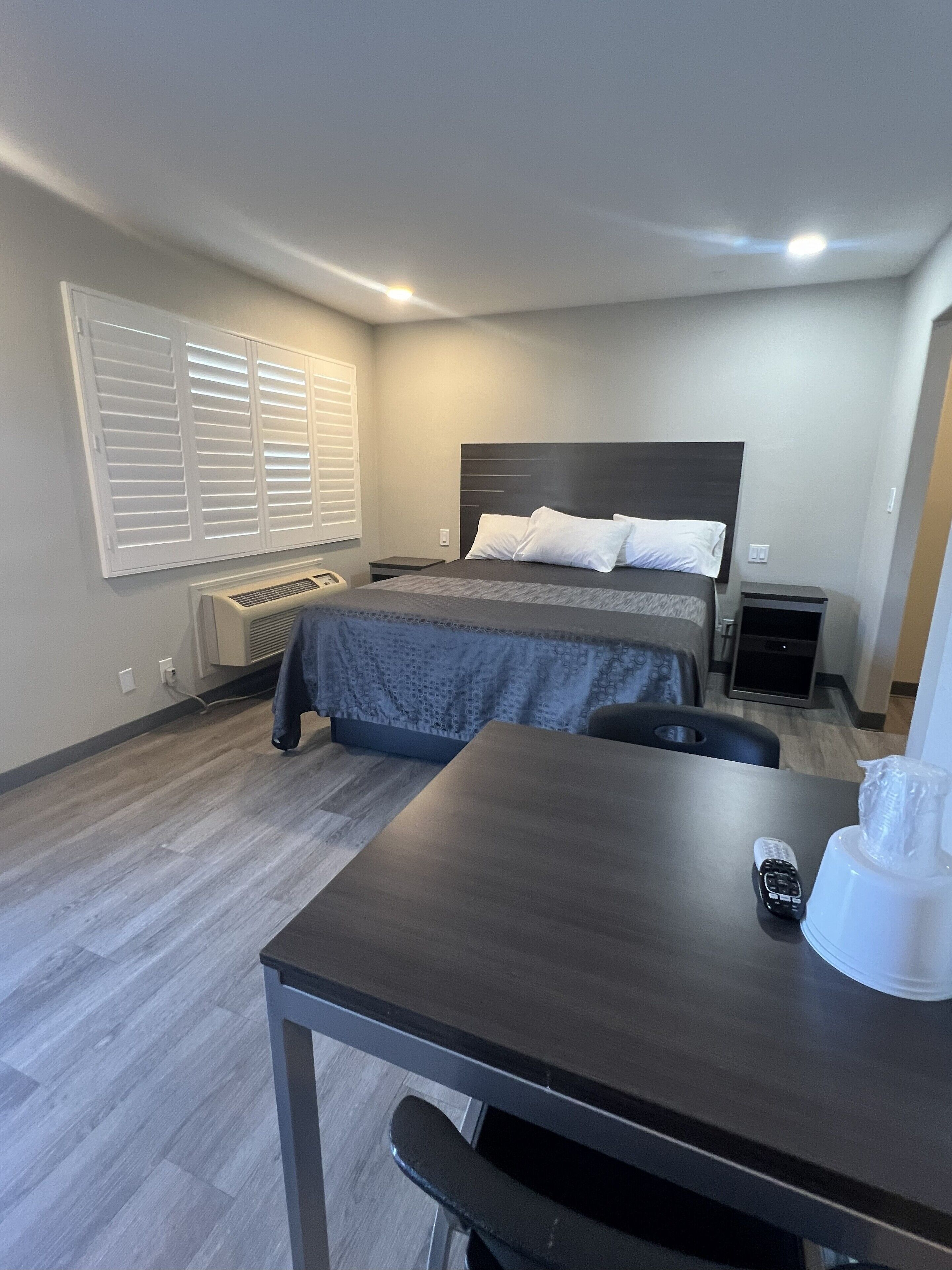 Une chambre d’hôtel avec un lit, des tables de chevet, un bureau et une chaise.