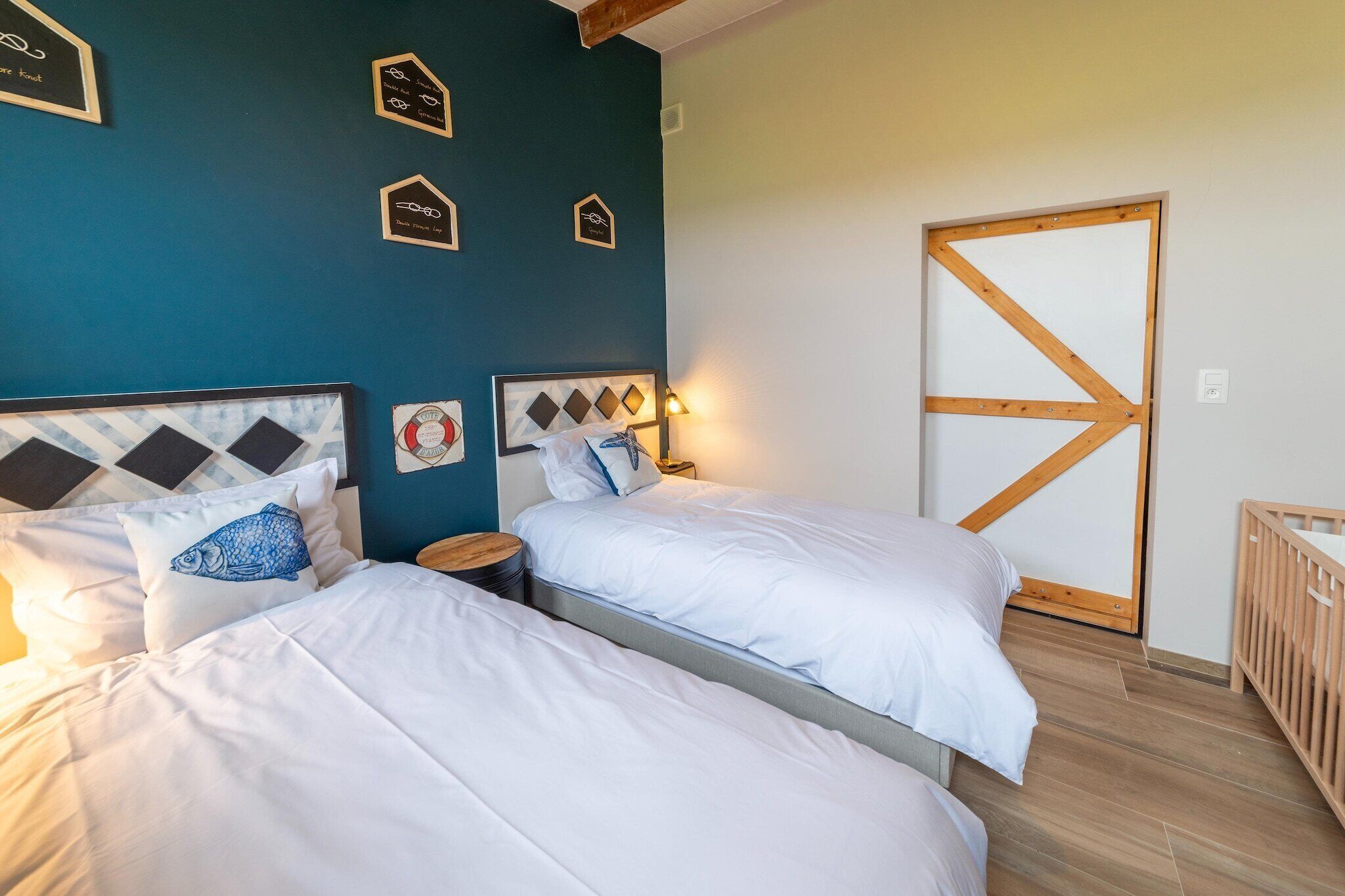 Un dormitorio con dos camas, una puerta de madera y adornos en la pared.