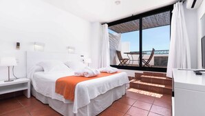 Una habitación de hotel con una cama, un escritorio, una silla y vistas al exterior.