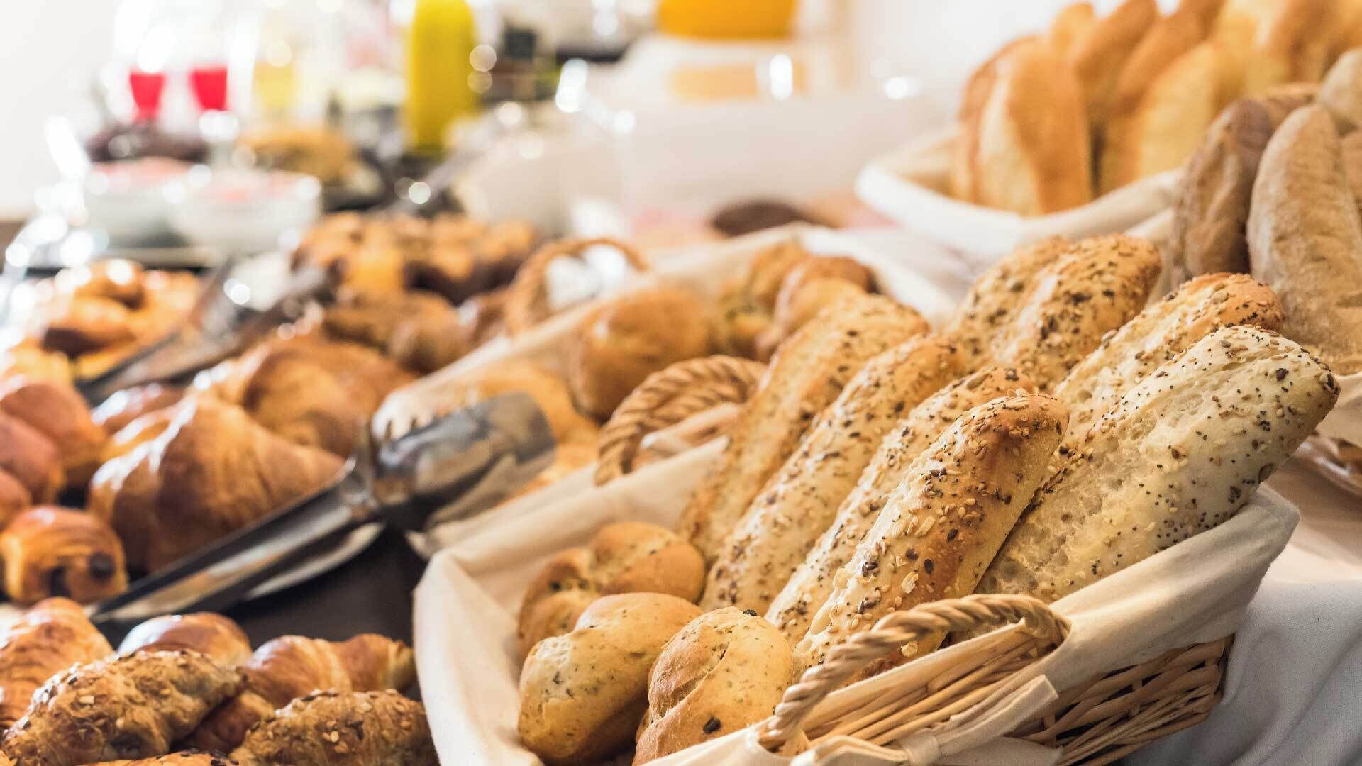 A variety of breads and pastries displayed in baskets.
