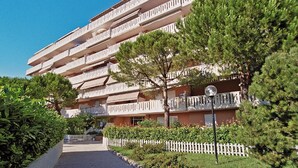 Ein mehrstöckiges Hotel mit Balkonen, einem Weg und Grünflächen.
