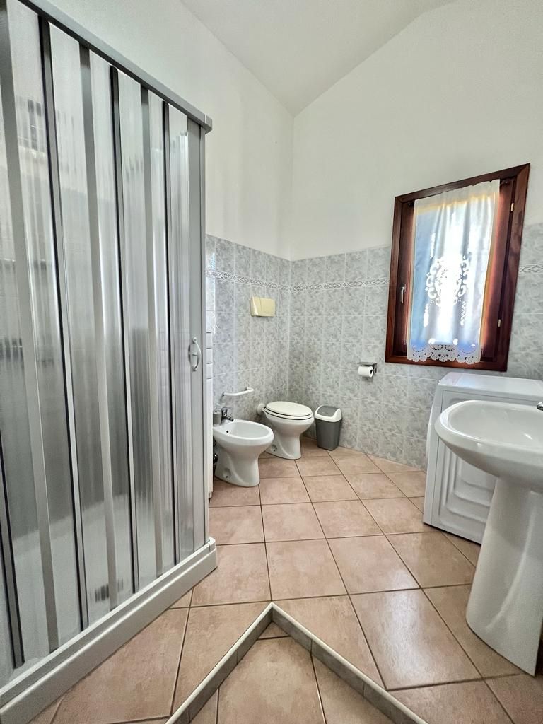 A bathroom with a toilet, bidet, and sink.