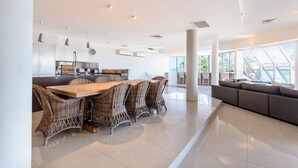 Een ruime, moderne keuken met een eethoek, grote ramen en uitzicht op de omgeving.