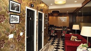 A hotel lobby with a checkered floor, a red sofa, and a chandelier. - Hotel Mayvillas Luxury Boutique Stay (Dehradun)