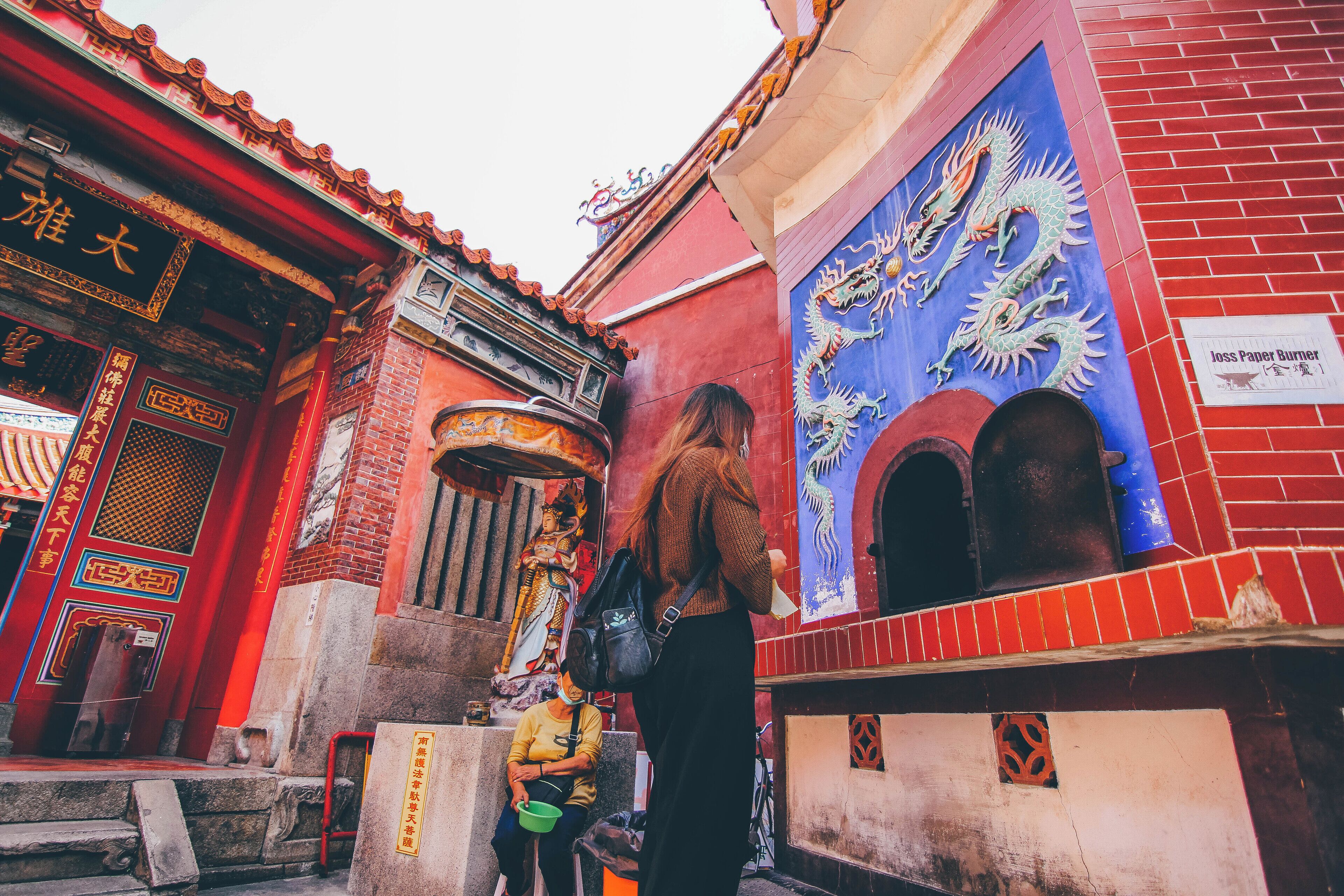 A traditional building with red walls and a dragon mural.
