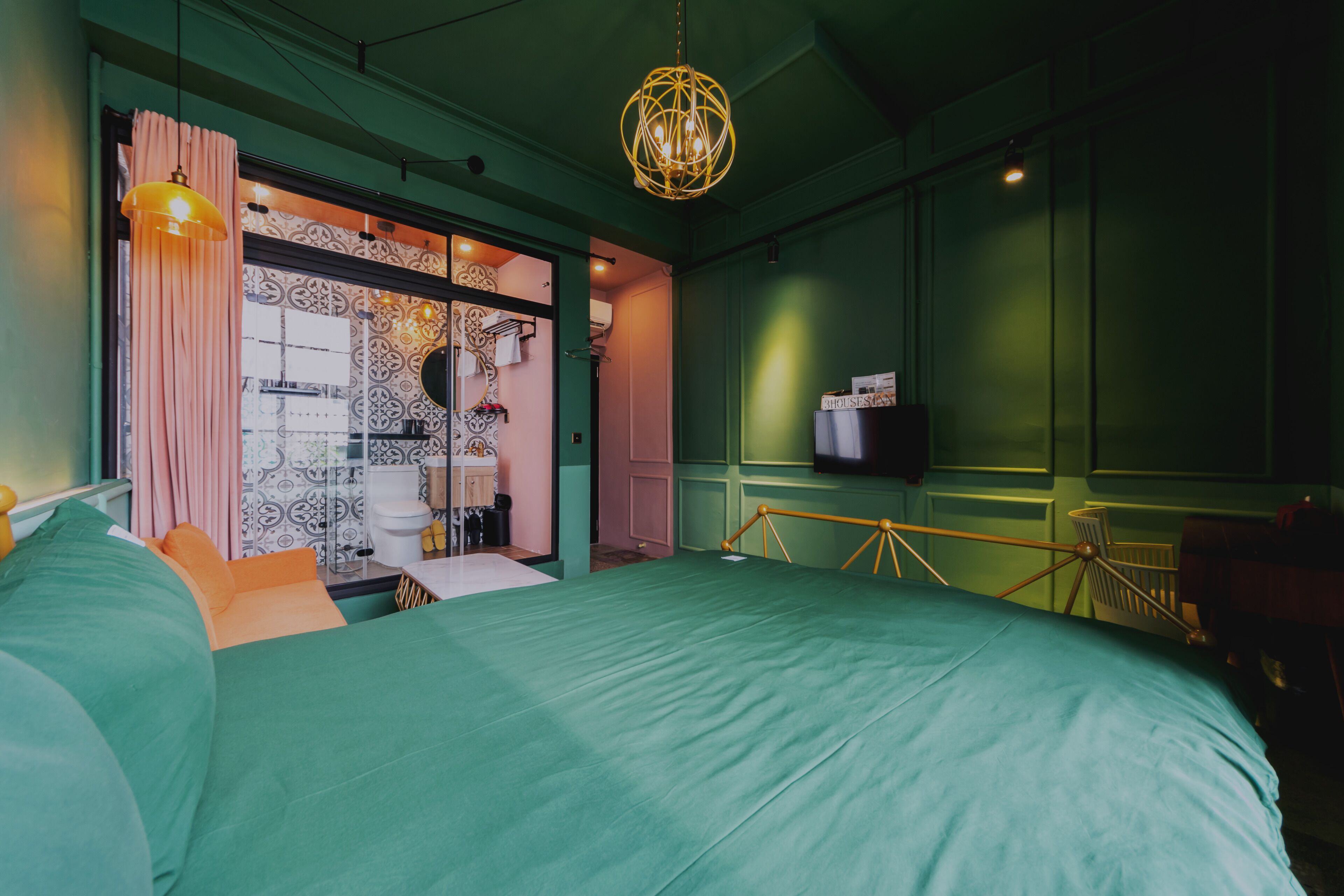 A modern bedroom with a large bed, a television, and a sliding door leading to a bathroom.