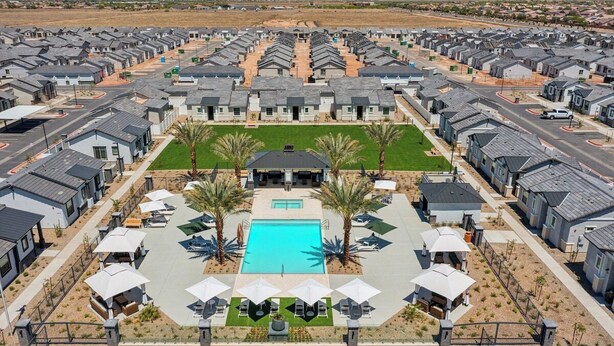 Un complexe résidentiel moderne comprenant plusieurs maisons, une piscine centrale et des espaces de détente en plein air.