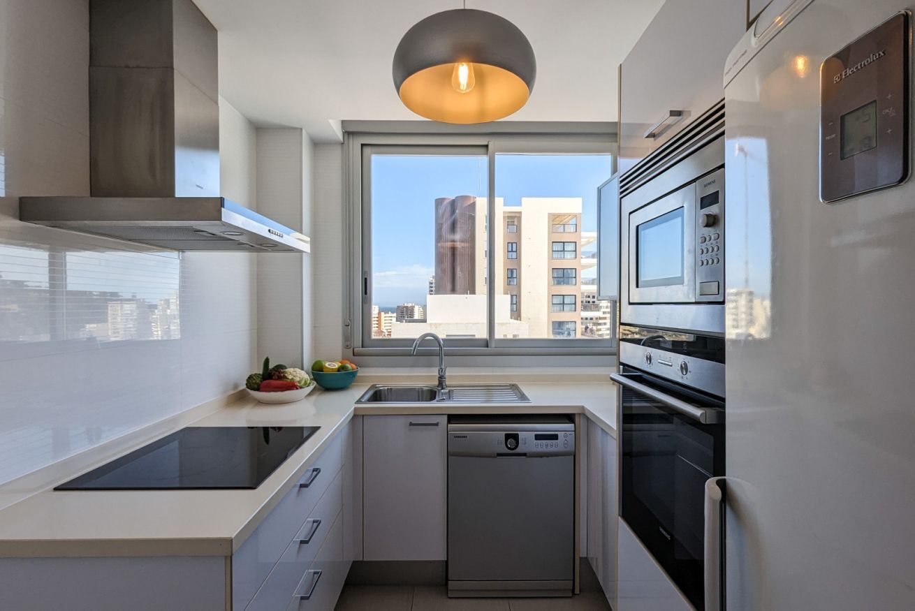 A modern kitchen with a dishwasher, oven, and microwave.