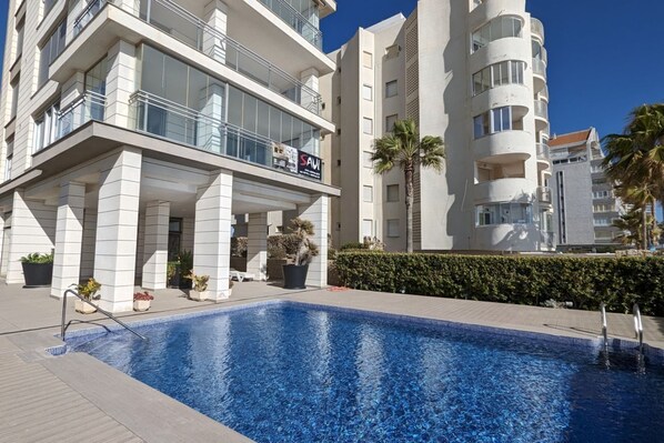 Un hôtel moderne doté d’une piscine, de balcons et d’une enseigne indiquant « SAVI ».