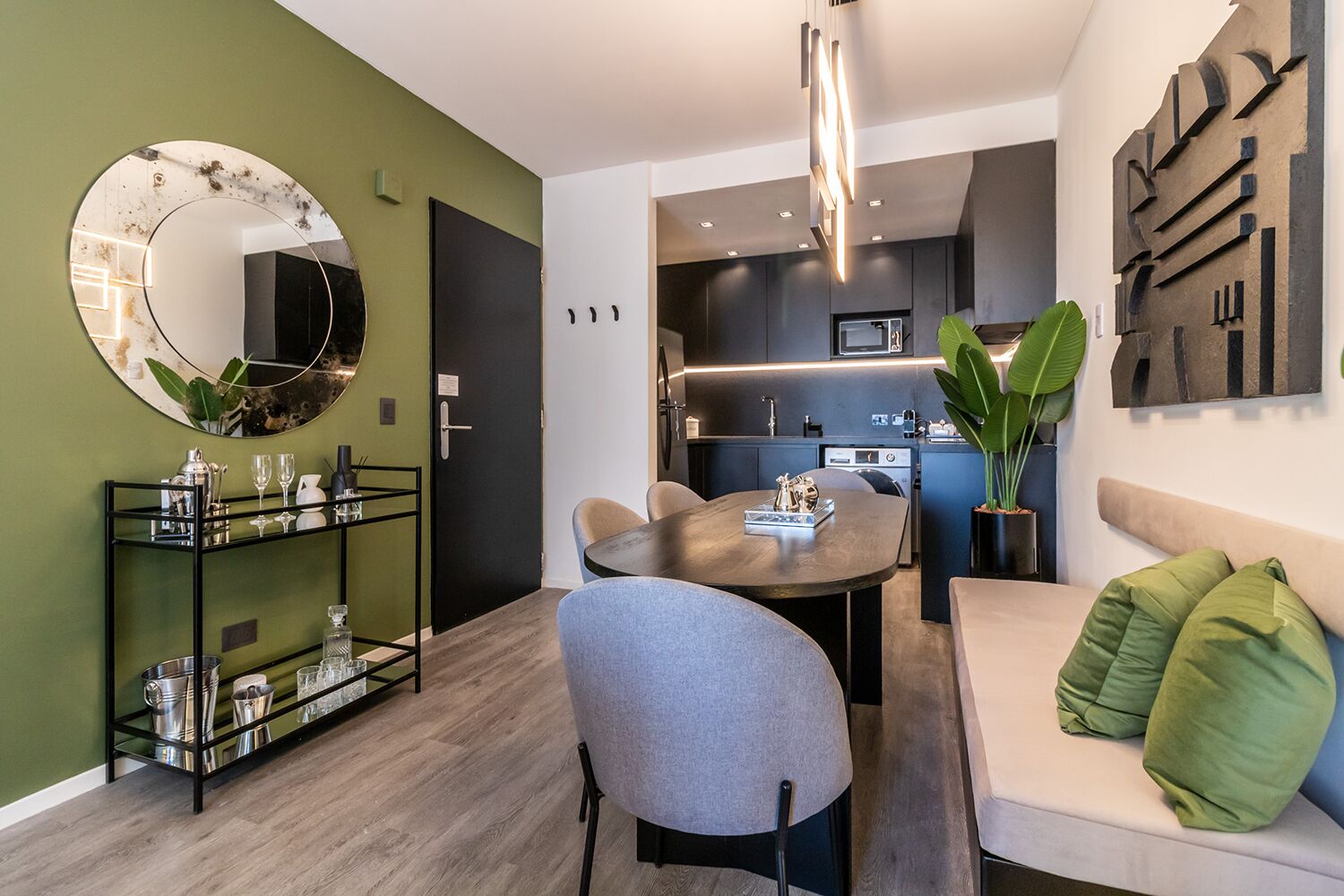 Un salon moderne avec un grand miroir rond, une table à manger et un canapé.