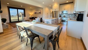 Una cocina moderna con comedor, ventanas amplias y vistas al exterior.