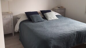 Ett sovrum med en säng, två sängbord och en vägglampa.