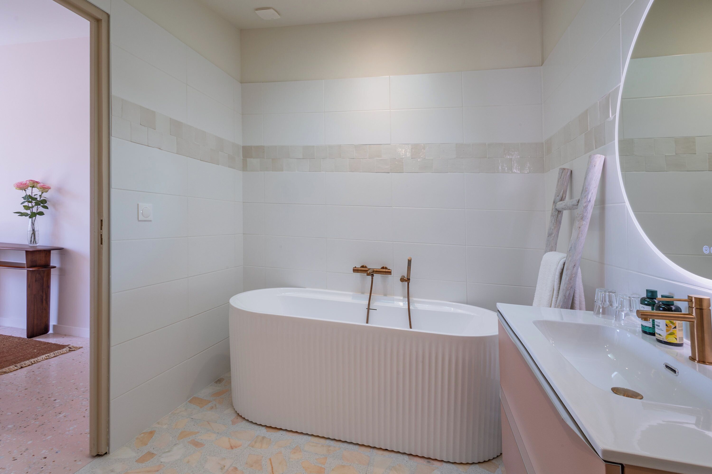 A modern bathroom with a freestanding bathtub, a vanity with a sink, and a mirror.