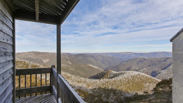A wooden cabin with a porch overlooking a mountainous landscape. - Shamrock 1 - Mt Hotham (Hotham Heights)
