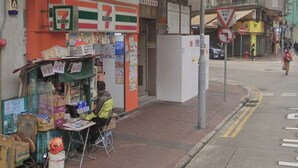 A 7-Eleven convenience store with a person sitting outside. - Tai Tung Hostel (Kowloon)