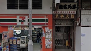 A 7-Eleven convenience store with a visible entrance and a person walking inside. - Tai Tung Hostel (Kowloon)