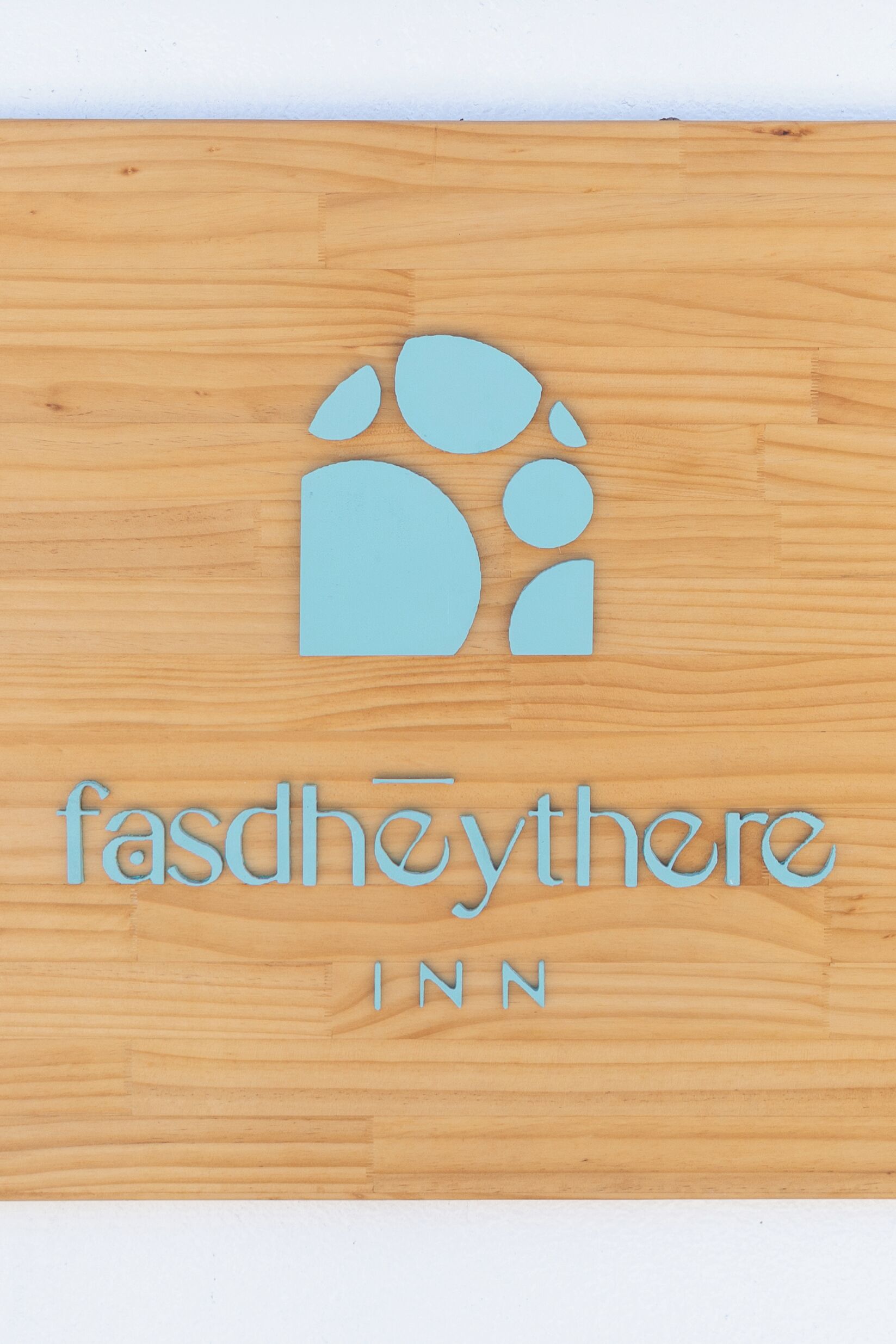 Un letrero de madera con un logotipo y el texto 'fasdhøythere INN'.