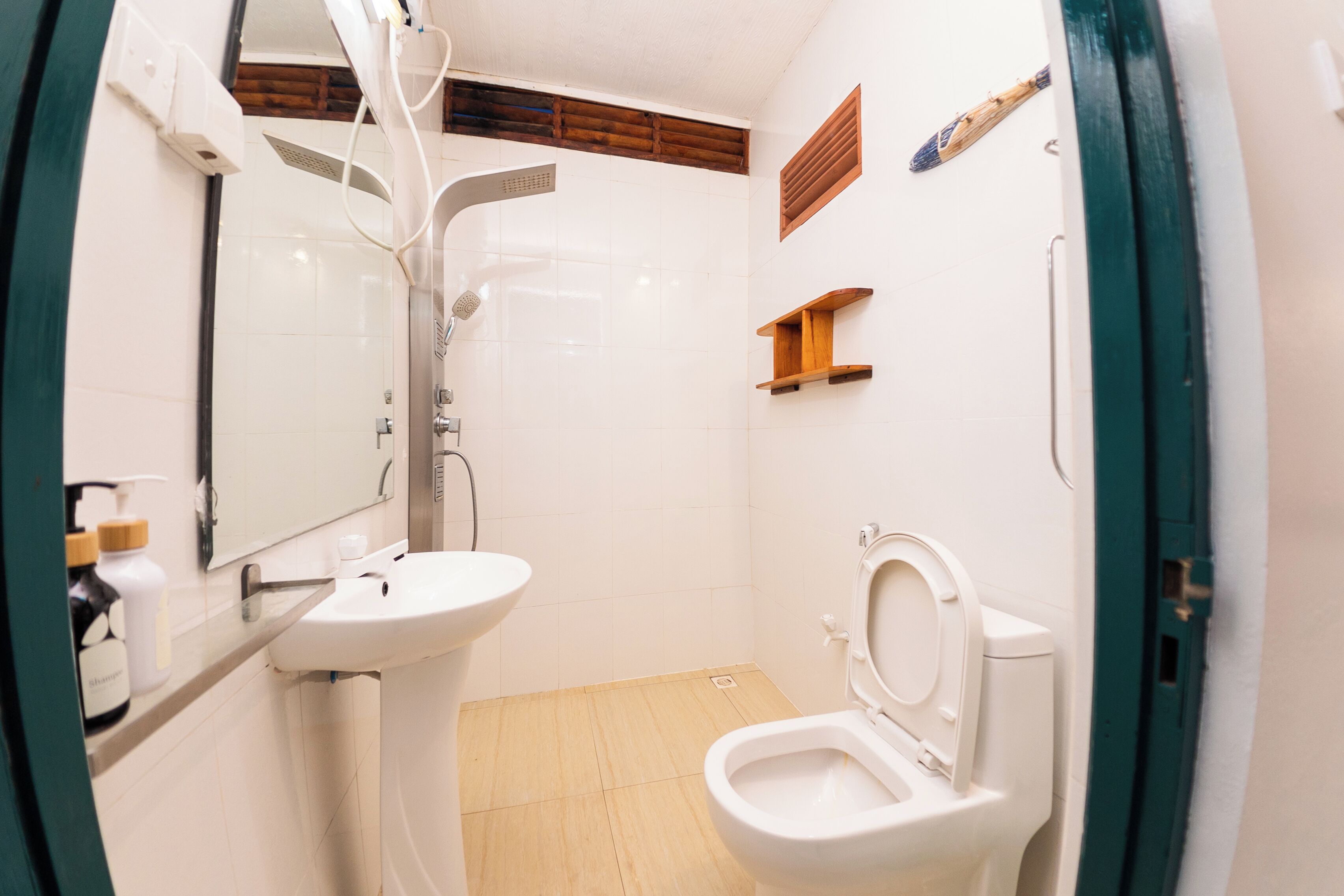 A bathroom with a white sink, a toilet, a shower, and a mirror.