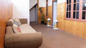 A cozy interior with a woven sofa, wooden walls, and a staircase. - Fasdheythere Inn (Kendhoo)