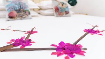 Cama com almofadas decorativas e um arranjo floral.