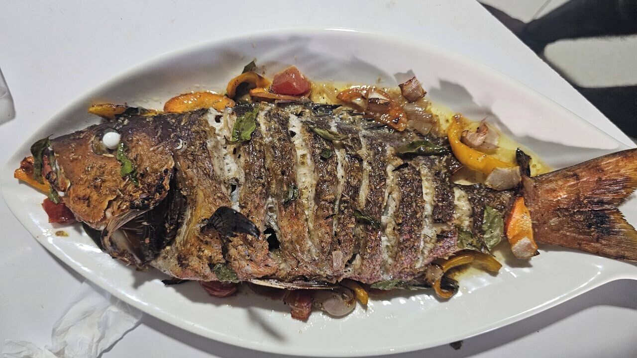 A grilled fish dish on a white plate.