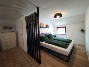 Cozy retreat with a bed, green bedspread, and natural light.