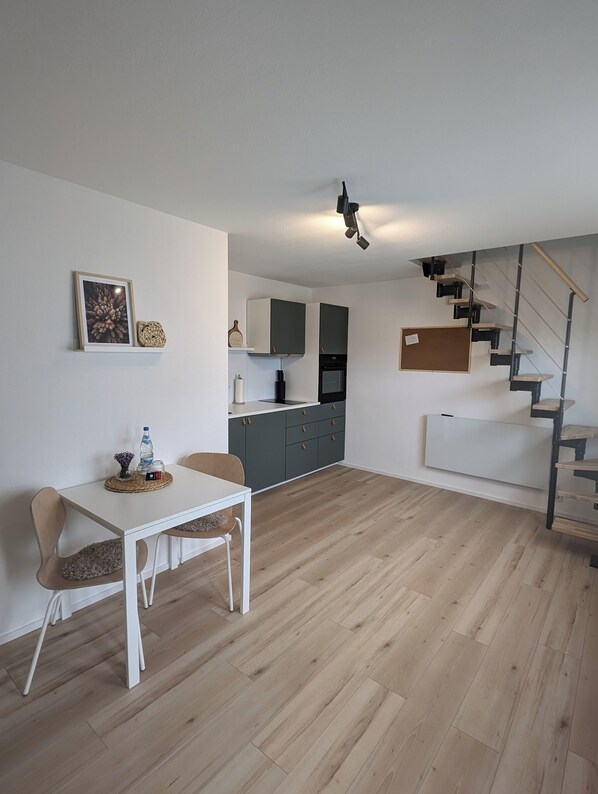 Enjoy a functional living space with a dining area, kitchen, and staircase.