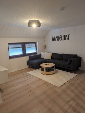 Relax in this stylish living room with a sofa, coffee table, and large window.