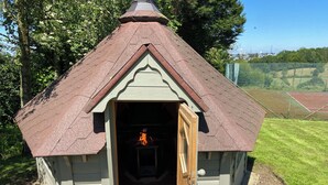 Eine kleine Holzhütte mit geneigtem Dach und einer Tür.