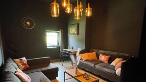 Ein modernes Wohnzimmer mit einer Couch, einem Couchtisch und hängenden Pendelleuchten.