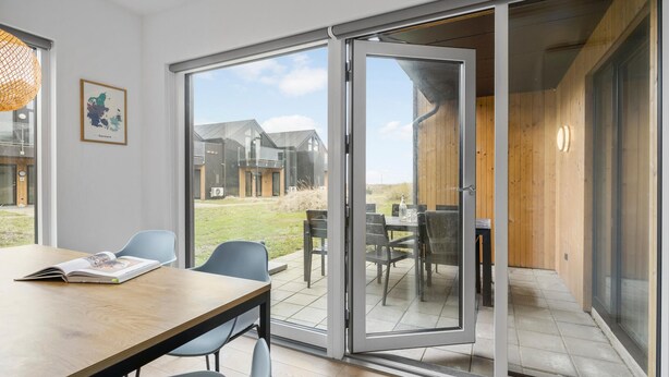 A modern interior with a dining area, a large sliding glass door leading to an outdoor patio, and a framed map on the wall. - Awesome apartment in Slagelse with WiFi (Slagelse)