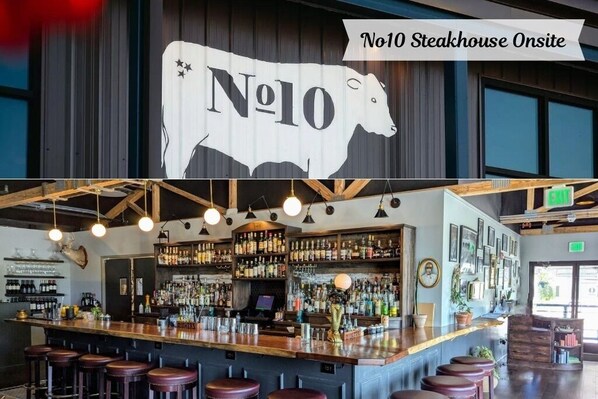A bar area with a large No10 Steakhouse sign, bar stools, and a well-stocked liquor shelf.