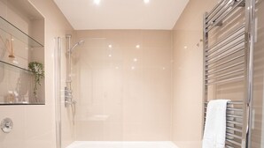 A modern bathroom with a glass shower enclosure, a white bathtub, and a glass-enclosed toilet. - Premier Three Bedroom Bliss City View Shoreditch (London)