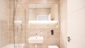 A modern bathroom with a glass-enclosed shower, a white sink, and a toilet. - One Bed Near Windsor Castle by Belvilla (Slough)
