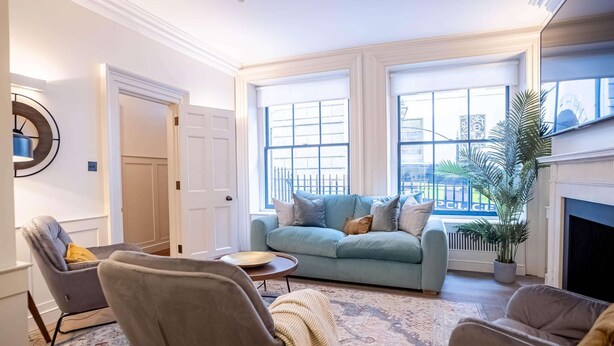 A living room with a light blue sofa, two armchairs, a coffee table, and a patterned rug. - Liverpool St Three Bedroom Home Near Tube Station (London)